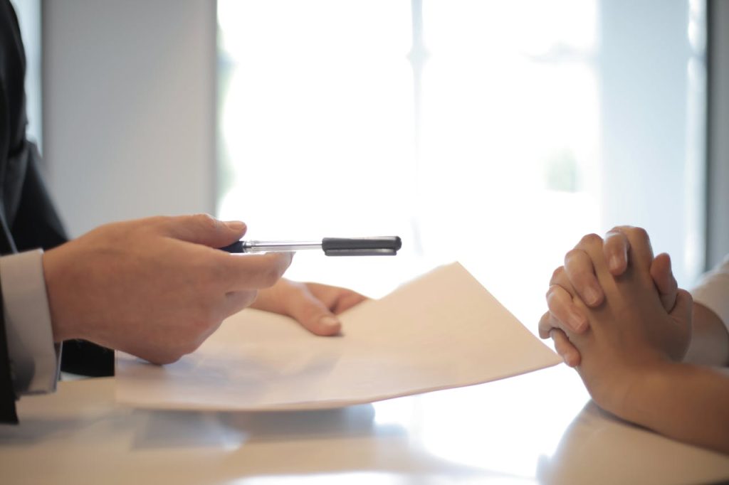 Protecting Your Future. Close-up of a contract signing with hands over documents. Professional business interaction.